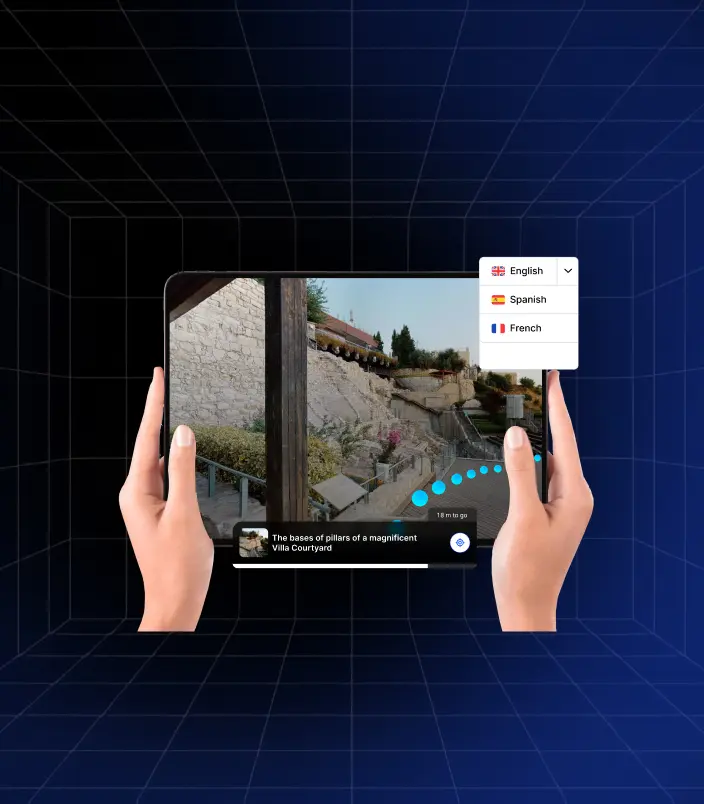 Hands hold a tablet displaying a Matterport digital twin of an outdoor archaeological site, possibly a villa courtyard. A language selection dropdown in the Treedis interface shows options for English, Spanish, and French, highlighting the platform's multilingual capabilities for indoor navigation and information within the virtual tour.